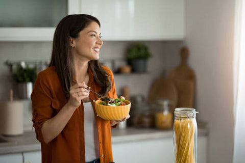 Woman enjoying a fresh salad in her kitchen